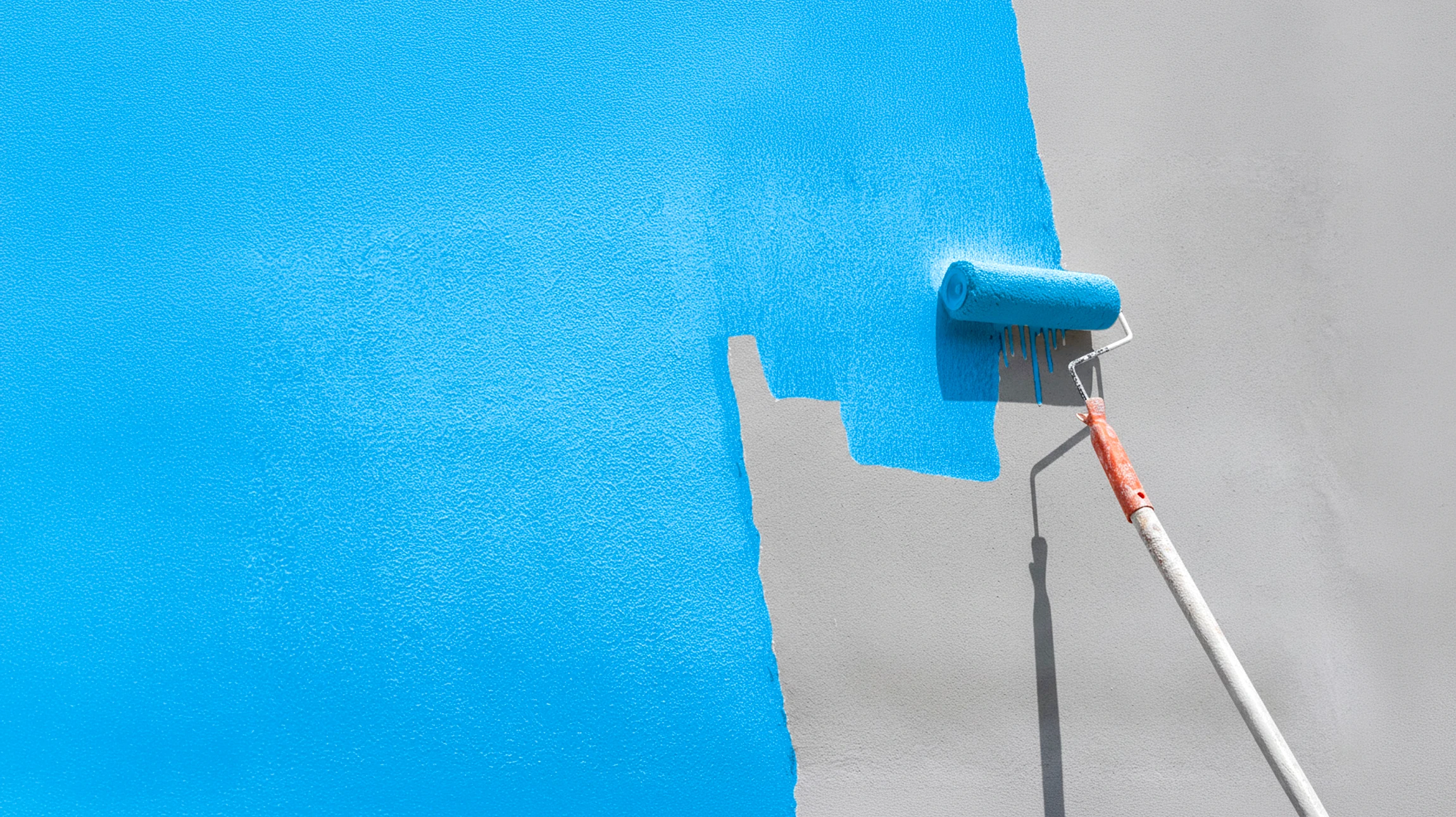 Peintre professionnel sur échelle appliquant de la peinture blanche sur bardage extérieur d'une maison à deux étages